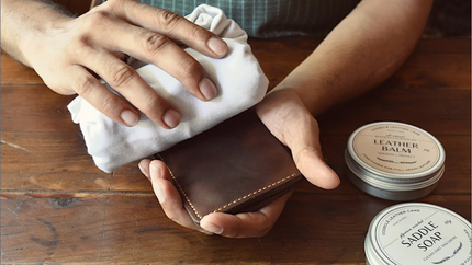 a person cleaning markore leather wallet with saddle soap
