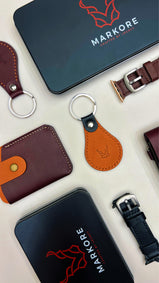 Collection of markore leather products including wallets, keychains, and watch straps with Markore branding.
