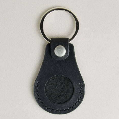 Front view of midnight black AirTag keychain in full-grain leather with round metal key ring and stainless steal press stud. Markore Tag Mate.