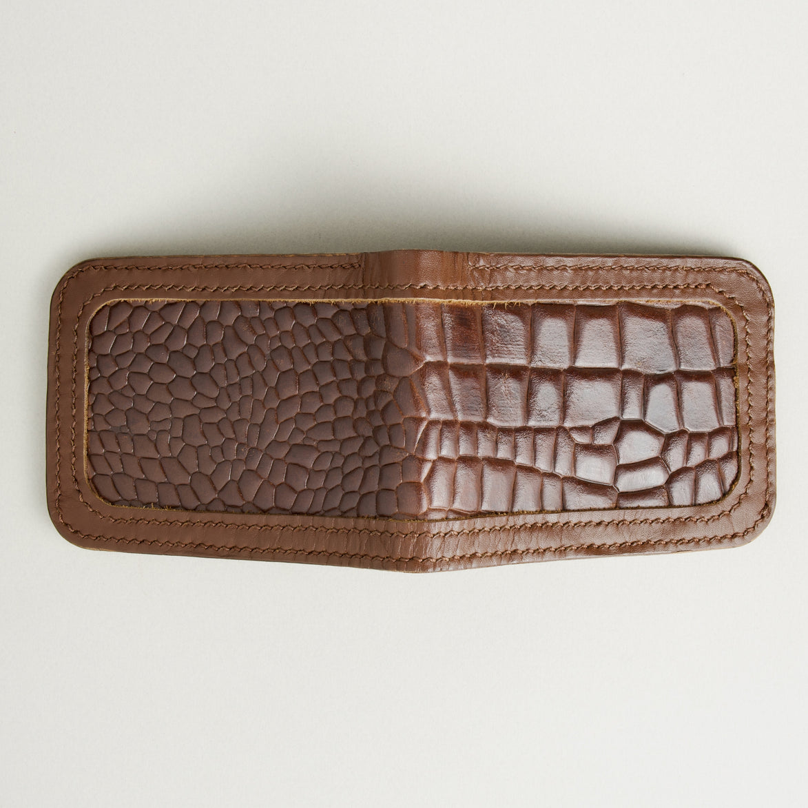 Outside view of espresso brown croc-embossed full-grain leather bifold wallet featuring handmade stitching. Markore Indus Sultan
