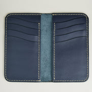 Inside view of vertical full-grain leather bifold wallet in dark blue, with cards lots and handmade stitching in ivory. Markore Karakoram II.