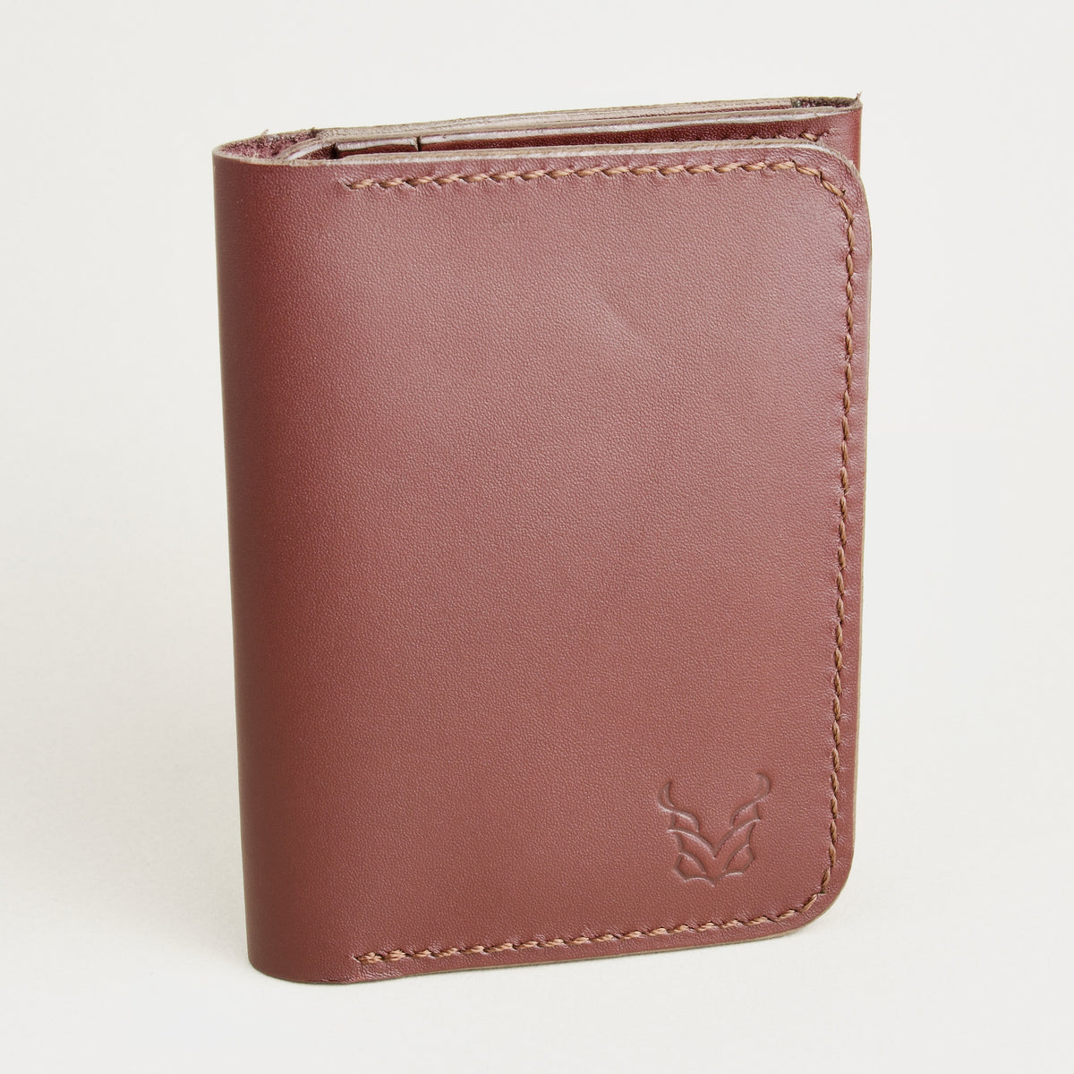 Front view of espresso brown full-grain leather flap fold wallet featuring a flap closure, handmade stitching and embossed logo. Markore Khaas Andaz.