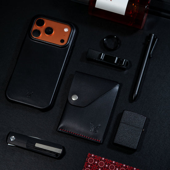 markore niva heritage in midnight black with red stitching and markore shell frame iphone 17 pro leather case sitting on a black surface
