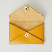 Front view of full grain leather envelope style wallet with open flap in amber with stainless steal press button. Markore Niva Seal.