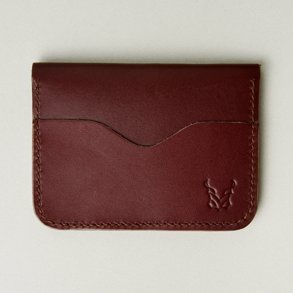 Front view of espresso brown full-grain leather wallet featuring card slot, handmade stitching and embossed logo. Markore Ravi Slip.