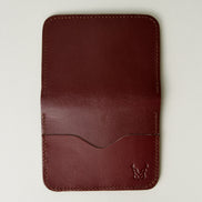 Outside view of espresso brown full-grain leather wallet featuring card slot, handmade stitching and embossed logo. Markore Ravi Slip.