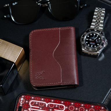 markore ravi slip slim bifold wallet in espresso brown sitting on a black table with rolex watch and phone with ajrak pattern wallpaper