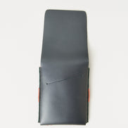 Back view of midnight black full-grain leather flap wallet with open flap featuring a card slot, and red handmade stitching. Markore Sutlej Vault.