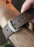 Person adjusting a brown leather markore hour line apple watch strap