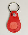 Front view of red AirTag keychain in full-grain leather with round metal key ring and stainless steel press stud. Markore Tag Mate.